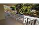 Private balcony area with decorative white railings offering serene views of mature landscaping at 2612 Pearce Dr # 211, Clearwater, FL 33764