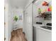 Well-organized laundry area with washer, dryer, storage shelves, and natural light from a nearby window at 3019 Royal Tuscan Ln, Valrico, FL 33594