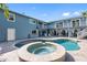 Large blue home featuring a two-story deck, large pool, and jacuzzi at 314 Pennsylvania Ave, Palm Harbor, FL 34683