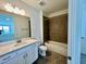 Bright bathroom boasting a white vanity, bathtub with tiled surround, and modern fixtures at 31857 Anchor Point Dr, Wesley Chapel, FL 33545