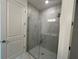Stylish bathroom with glass enclosed shower featuring elegant marble-look tiling and modern fixtures at 31857 Anchor Point Dr, Wesley Chapel, FL 33545