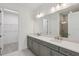 Spacious bathroom featuring double sinks, large mirror, modern lighting, and a glass-enclosed shower at 31857 Anchor Point Dr, Wesley Chapel, FL 33545