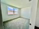 Inviting bedroom with neutral carpet, a large window, and clean, minimalist design at 31857 Anchor Point Dr, Wesley Chapel, FL 33545