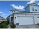 Two-story home showcasing a two-car garage, blue siding, and a well-maintained brick walkway at 31857 Anchor Point Dr, Wesley Chapel, FL 33545
