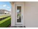 Front door with glass inset with view to the interior and brick paver stoop, and well maintained lawn at 31857 Anchor Point Dr, Wesley Chapel, FL 33545