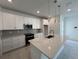 Bright kitchen with white cabinetry, stainless steel appliances, quartz countertops, and sleek modern design at 31857 Anchor Point Dr, Wesley Chapel, FL 33545