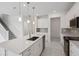 Modern kitchen with stainless steel appliances, gray backsplash, large island, and white cabinetry at 31857 Anchor Point Dr, Wesley Chapel, FL 33545