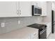 Close-up of a kitchen with white cabinets, tile backsplash, and stainless appliances at 31857 Anchor Point Dr, Wesley Chapel, FL 33545