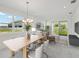 Living and dining area with a large table, stylish furniture, and natural light from the large windows at 31857 Anchor Point Dr, Wesley Chapel, FL 33545