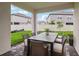 Covered patio features brick pavers, lawn views and a modern outdoor dining set at 31857 Anchor Point Dr, Wesley Chapel, FL 33545