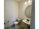 Clean powder room featuring a pedestal sink, round mirror, and tiled floors at 31857 Anchor Point Dr, Wesley Chapel, FL 33545