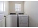 Laundry room with white washer and dryer, white walls, and a small window at 32673 Pez Landing Ln, Wesley Chapel, FL 33543