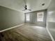 Bedroom features two windows with blinds, light gray walls, wood-look flooring, and a ceiling fan at 3413 N 72Nd St, Tampa, FL 33619