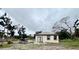 Shows the back of the house, featuring a door leading to the backyard and windows for natural light at 3413 N 72Nd St, Tampa, FL 33619