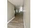 Long hallway features wood flooring and fresh gray paint connecting to kitchen area at 3413 N 72Nd St, Tampa, FL 33619