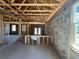 Interior view showing exposed wood framing, concrete floors, and newly installed windows at 3413 N 72Nd St, Tampa, FL 33619