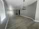 Spacious living room featuring contemporary light fixtures, gray walls, white trim, and attractive wood-look flooring at 3413 N 72Nd St, Tampa, FL 33619