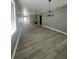 Spacious living room featuring contemporary light fixtures, gray walls, white trim, and attractive wood-look flooring at 3413 N 72Nd St, Tampa, FL 33619