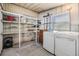 Functional laundry room with washer, dryer, storage shelves and additional shelving space at 37838 Granada Ave, Zephyrhills, FL 33541