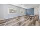 Bright living room featuring modern floors, two windows, and a blue accent wall at 37838 Granada Ave, Zephyrhills, FL 33541
