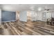 Open-concept living room showcasing modern floors, a blue accent wall, and access to the kitchen at 37838 Granada Ave, Zephyrhills, FL 33541