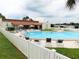 Community pool area with lounge chairs, umbrellas, and the clubhouse creating a great recreation space at 37838 Granada Ave, Zephyrhills, FL 33541