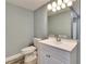 Bathroom includes a commode, single sink vanity, mirror, and modern lighting fixtures at 39809 Pretty Pond Rd, Zephyrhills, FL 33540