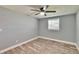 This bedroom features new floors, a ceiling fan, and a window providing natural light at 39809 Pretty Pond Rd, Zephyrhills, FL 33540