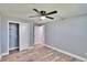 This spacious bedroom features a ceiling fan, closet, and gray wood flooring at 39809 Pretty Pond Rd, Zephyrhills, FL 33540