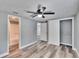This spacious bedroom features a ceiling fan, closet, and gray wood flooring at 39809 Pretty Pond Rd, Zephyrhills, FL 33540
