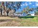 Charming single-story home featuring a large, grassy yard and a detached storage shed at 39809 Pretty Pond Rd, Zephyrhills, FL 33540