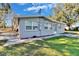 Home exterior with well-maintained lawn, mature trees, and a side patio at 39809 Pretty Pond Rd, Zephyrhills, FL 33540
