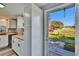 Cozy kitchen with butcher block countertops, white cabinetry, and a view to the property's front yard at 39809 Pretty Pond Rd, Zephyrhills, FL 33540