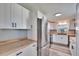 Renovated kitchen with white cabinetry, stainless steel appliances, butcher block countertops, and sleek black hardware at 39809 Pretty Pond Rd, Zephyrhills, FL 33540