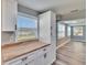 Charming kitchen with butcher block countertops, white cabinetry, and views into the living room at 39809 Pretty Pond Rd, Zephyrhills, FL 33540