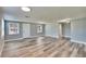 Bright, open living room features new gray wood flooring and abundant natural light through multiple windows at 39809 Pretty Pond Rd, Zephyrhills, FL 33540