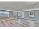 Bright, open living room features new gray wood flooring and abundant natural light through multiple windows at 39809 Pretty Pond Rd, Zephyrhills, FL 33540