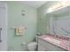 A bathroom features a toilet, a vanity with a pink granite countertop, and a shower at 6190 80Th N St # 409, St Petersburg, FL 33709