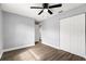 Bedroom with gray walls, wood-look laminate flooring, ceiling fan, and closet doors at 6401 Elmhurst Ct, Pinellas Park, FL 33782