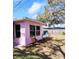 Pink home with view of the backyard featuring blue lawn chair at 675 Marjon Ave, Dunedin, FL 34698