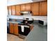 Kitchen view featuring stainless steel appliances, wooden cabinets, and neutral countertops at 675 Marjon Ave, Dunedin, FL 34698