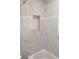 Elegant shower with sleek marble-style tile and a built-in niche for storage at 675 Marjon Ave, Dunedin, FL 34698