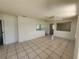 Open living area featuring tile floors, ceiling fan, and pass-through to kitchen at 6935 W Mohawk Ave, Tampa, FL 33634