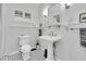 Bright bathroom features a pedestal sink, tiled floor, and window with white shutters at 732 Oak Ne St, St Petersburg, FL 33701