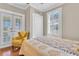 Comfortable bedroom featuring French doors, shuttered windows, and a cozy yellow chair at 732 Oak Ne St, St Petersburg, FL 33701