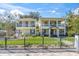 Charming, bright yellow two-story home featuring dual balconies and a well-manicured front lawn at 732 Oak Ne St, St Petersburg, FL 33701