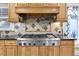 Close-up of a stainless steel gas range, wooden cabinetry, decorative backsplash, and sleek countertops at 732 Oak Ne St, St Petersburg, FL 33701