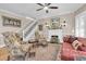Cozy living room featuring a fireplace, ceiling fan, staircase and comfortable floral print furniture and a reddish leather sofa at 732 Oak Ne St, St Petersburg, FL 33701