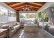 Outdoor screened-in patio featuring a ceiling fan, stone flooring, exterior access, and stone firepit and furniture at 732 Oak Ne St, St Petersburg, FL 33701