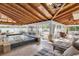 Enclosed pool area featuring light-colored stone flooring, a wood beam ceiling, and plenty of comfortable seating at 732 Oak Ne St, St Petersburg, FL 33701